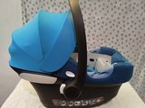 a baby car seat with a blue cover and a teddy bear in it