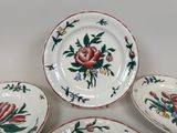 three plates with flowers on them are sitting on a table