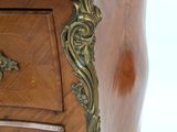 a wooden chest of drawers with a marble top