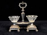 two glass bowls and a silver plate on a black surface