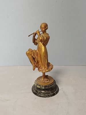 une statue en or représentant une femme jouant de la flûte