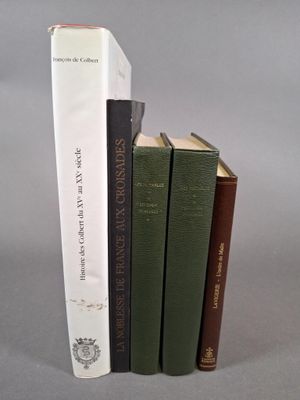 trois livres sont empilés sur une surface grise