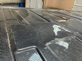 a dirty car that has been painted black with a flag on it