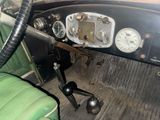 a dashboard of an old car with gauges and a steering wheel