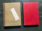 two red books sitting on top of a table next to each other