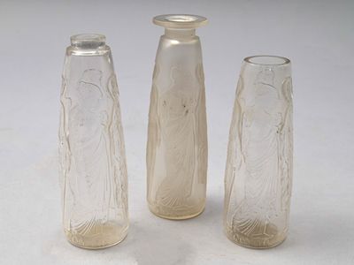 trois vases en verre posés l'un à côté de l'autre sur une table