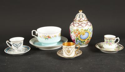 cinq tasses et soucoupes posées sur une surface noire