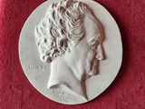 une image représentant une médaille d'argent sur laquelle figure le visage d'un homme
