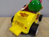 a yellow toy car with a green pig on top of it