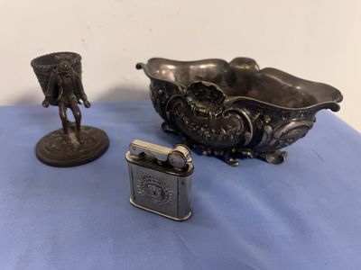 a small lighter sitting next to a metal bowl