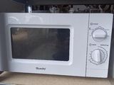 a white microwave sitting on a shelf in a kitchen