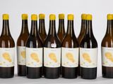 six bouteilles de vin sont alignées sur une surface blanche