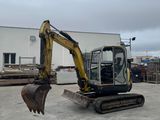 an image of a small excavator in a parking lot