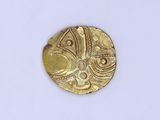 une vieille pièce d'or sur une surface blanche avec un fond blanc
