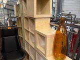 un vase posé sur une étagère en bois, à côté d'une chaise