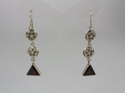 a pair of silver earrings with red glass beads on them