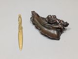 bronze figurine of a woman in a boat and a gold spoon