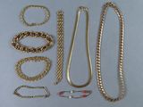 plusieurs types de chaînes et de bracelets en or disposés sur une table