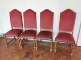 quatre chaises rouges avec des pieds en bois et une assise rembourrée rouge