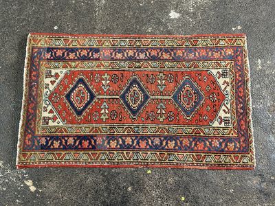 un tapis rouge et bleu posé sur un sol en béton