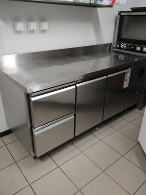 une cuisine en inox équipée d'un micro-ondes et d'un lave-vaisselle