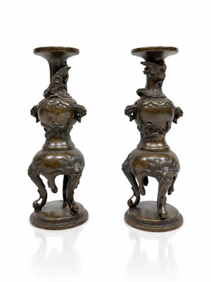 paire de vases anciens en bronze représentant des chevaux sur des socles, sur fond blanc
