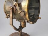 an old fashioned brass light on a wooden base on a gray background