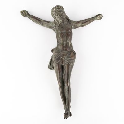 a bronze statue of jesus on the cross on a white background