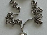 a silver chain with a pendant on it on a table