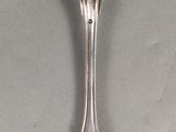 une cuillère en argent dont le manche a la forme d'un coquillage