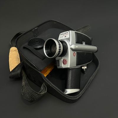 un sac noir contenant un appareil photo et une paire de ciseaux
