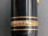 a close up of a fountain pen with a gold band on it