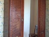 une photo d'une chambre à coucher avec une grande armoire en bois
