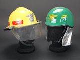 pair of yellow and green hard hats on display on black background