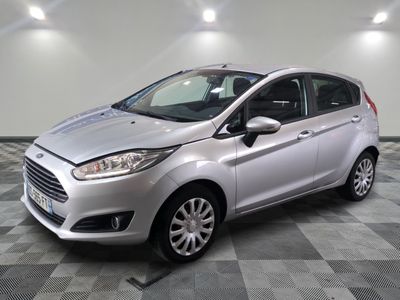 une Ford Fiesta argentée garée sur un sol à damier dans un garage