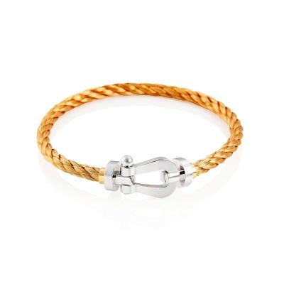 a gold braid bracelet with a silver clasp on a white background