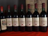 several bottles of red wine are lined up on a table