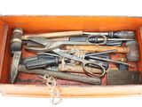 many different tools in a wooden box on a white surface