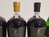 three bottles of wine are lined up on a table