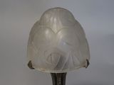 a lamp that has a glass shade on top of it