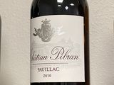 une bouteille de vin posée sur une étagère à côté d'un verre de vin