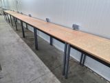 a long wooden table with metal legs in the middle of a room