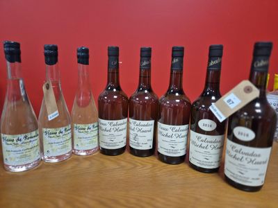 plusieurs bouteilles de vin sont alignées sur une table en bois