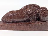 a chocolate sculpture of a lion laying on top of a rock