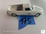 une petite voiture blanche ornée d'un ruban bleu