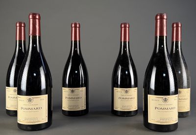 quatre bouteilles de vin sont alignées sur une table