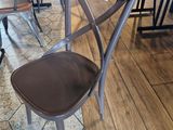 une table et des chaises en bois dans un magasin, avec des étiquettes de prix dessus