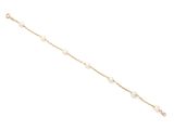 un bracelet en chaîne d'or orné de perles sur fond blanc