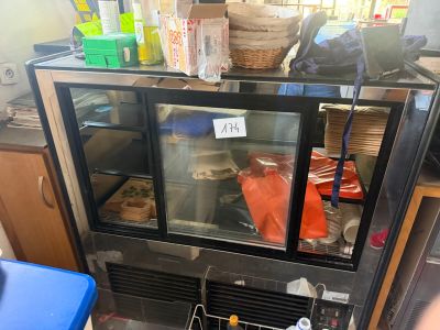 a glass case with food inside of it in a kitchen