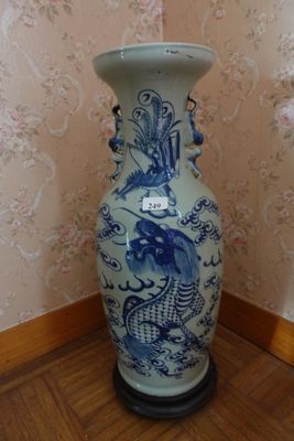 un grand vase bleu et blanc posé sur un parquet